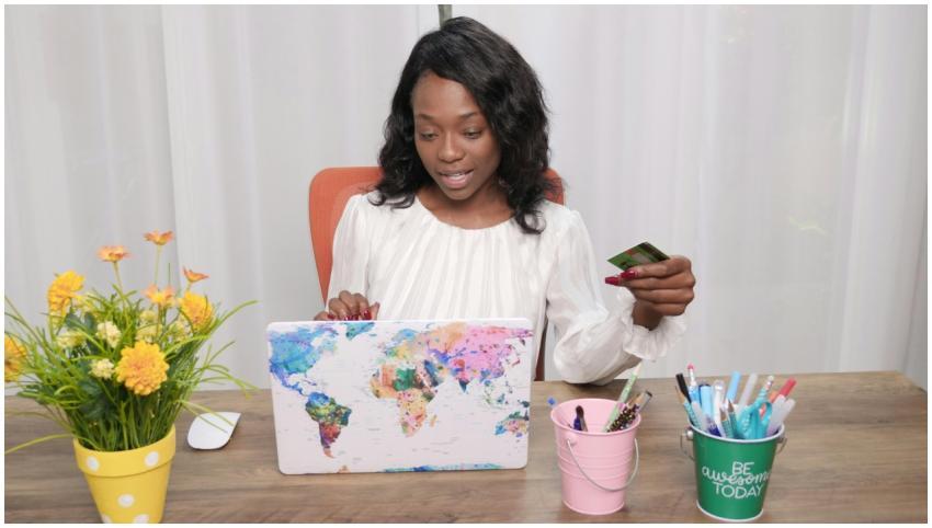 Black woman in a white blouse online shopping usin