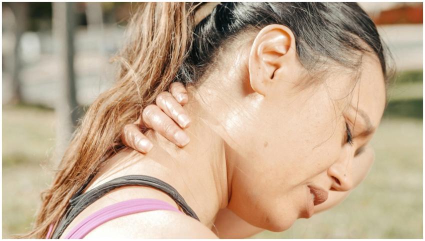 Close-up of a woman holding her neck, showing disc