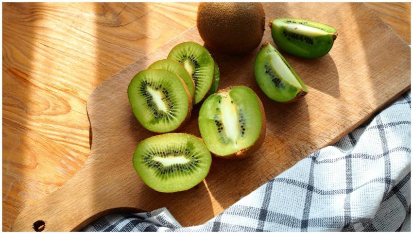 Close-up of fresh kiwi fruit slices on a wooden cu