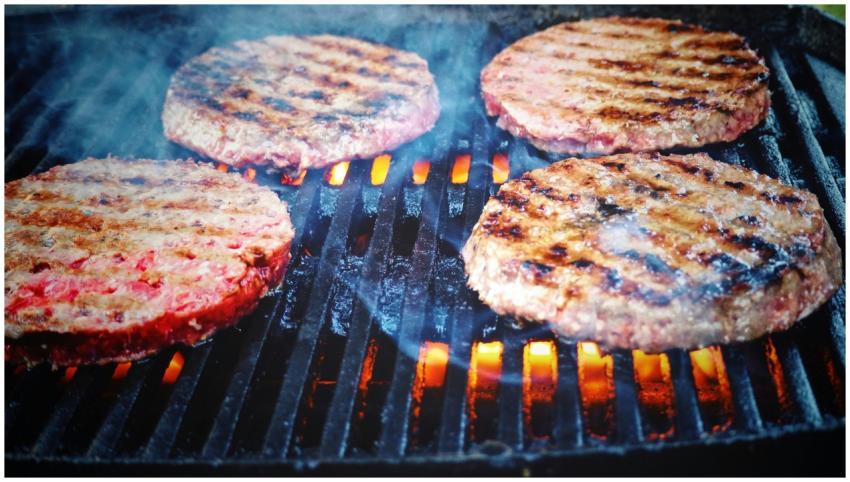 Juicy beef patties cooking on a hot grill, perfect