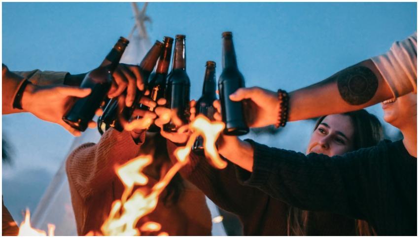 A group of friends enjoying a bonfire, clinking be