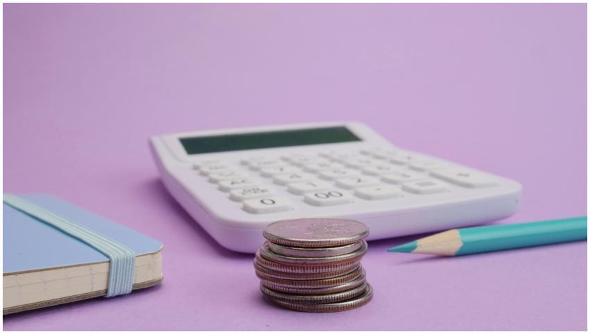 Calculator, coins, and stationery symbolize budget