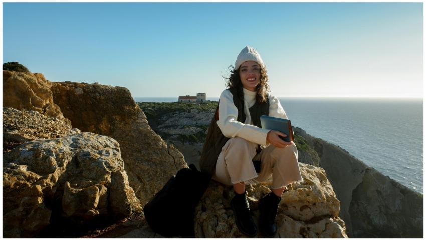 Smiling woman sitting with a book on scenic Sesimb