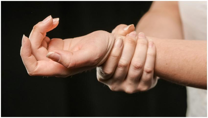 A close-up image of hands grasping a wrist, showca