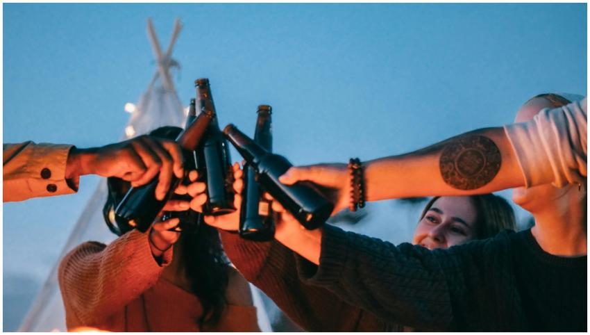 A cheerful group toasting with beer bottles around