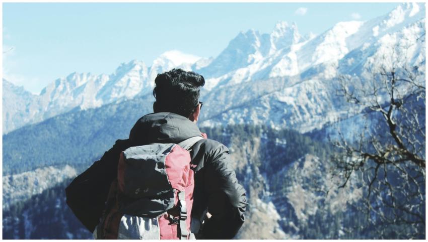 A backpacker admires the snowy peaks in Shimla, In