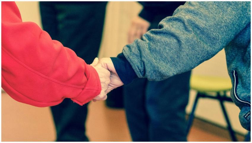 Close-up of elderly hands holding, symbolizing fri