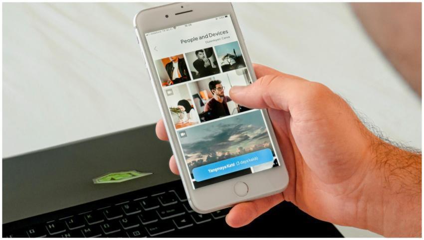Close-up of a hand browsing photos on a smartphone