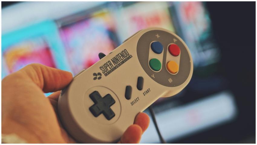 Hand holding a classic Super Nintendo game control