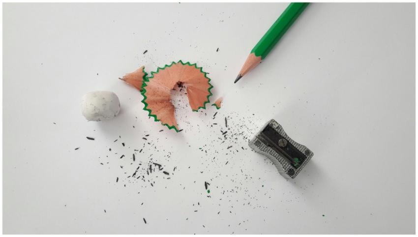 Close-up of pencil, sharpener, and eraser on a cle