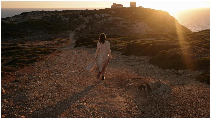 A woman walks along a coastal cliff path during go