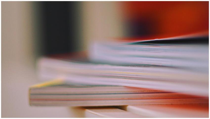 Blurred close-up of stacked books and magazines, s
