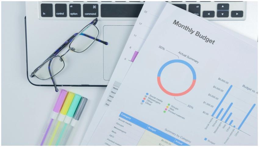 A clean office desk setup featuring a laptop, glas