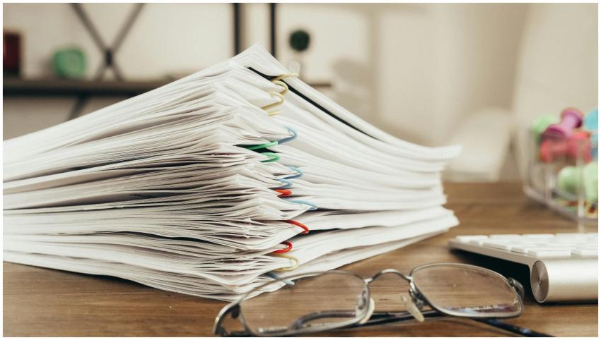 Close-up of a stack of office papers on a desk wit