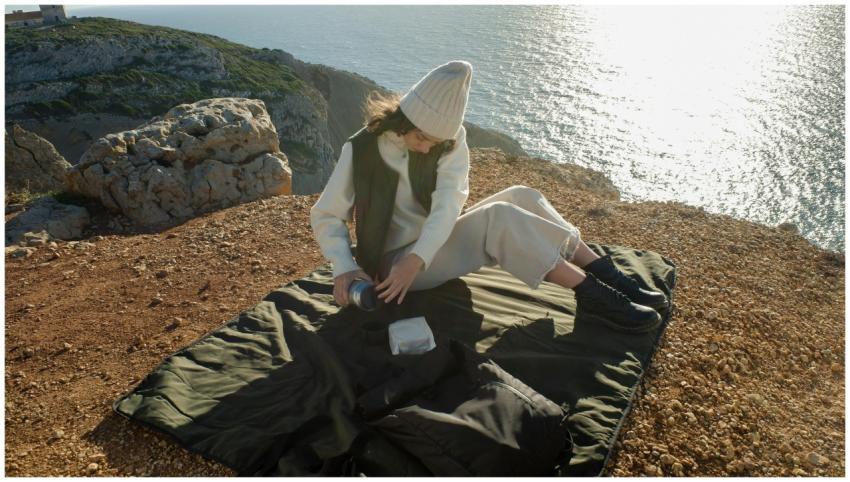 A woman in a knit hat enjoying a peaceful picnic o