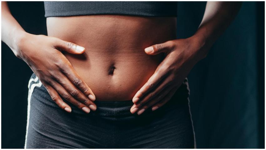 Close-up image of hands on abdomen signifying well