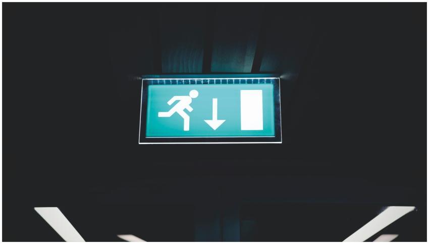Brightly lit emergency exit sign with arrow indica