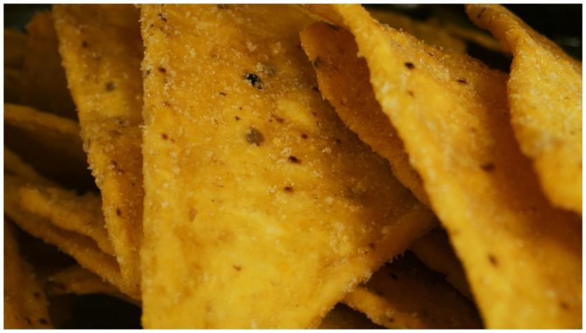 Macro shot of crunchy yellow corn chips with seaso