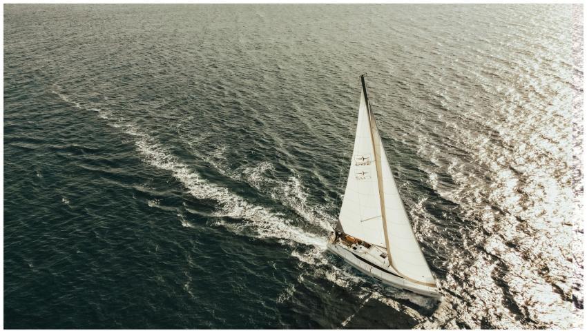 Stunning aerial shot of a sailboat cruising on the