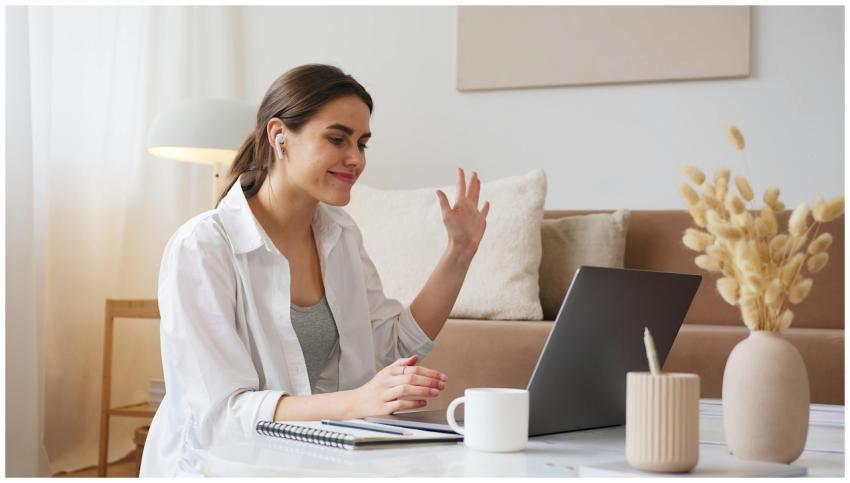 Cheerful young woman using laptop for a video call