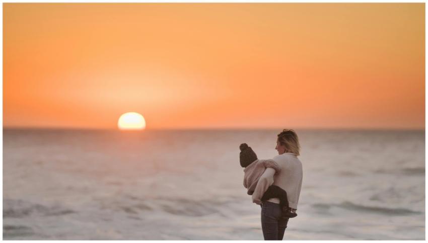 A mother embraces her child while watching the ser