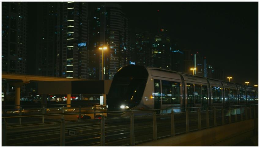 A modern train speeds through a city at night, sur