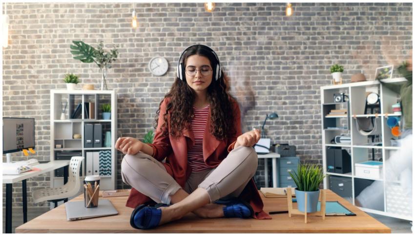 Young woman meditating with headphones in a modern