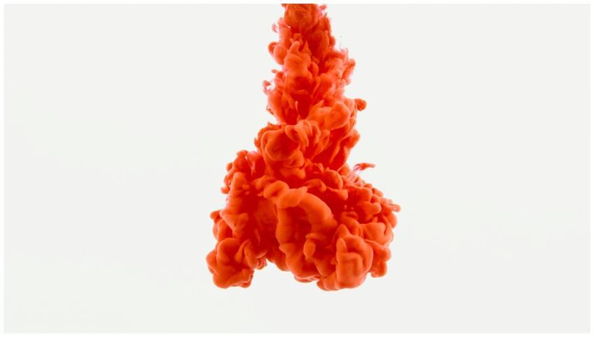 Dynamic orange ink swirling beautifully in clear w