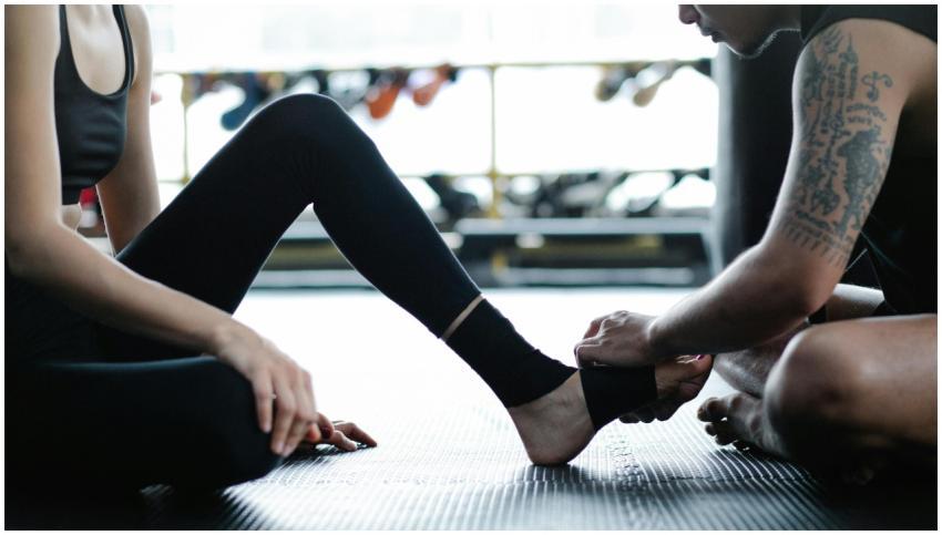 Two adults in gym attire preparing for a fitness s
