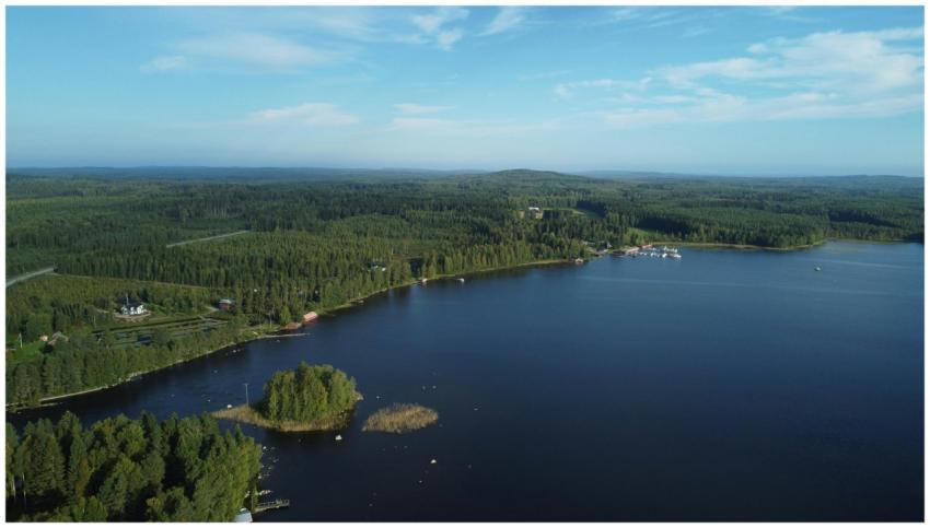 Drone shot showcasing a serene Finnish lake surrou