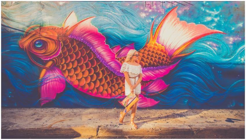 A colorful mural with a woman nearby, showcasing a