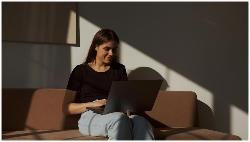Casual woman enjoying free time browsing laptop on
