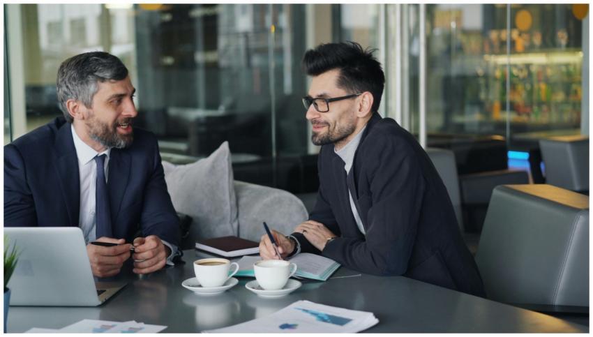 Two businessmen having a discussion over coffee in