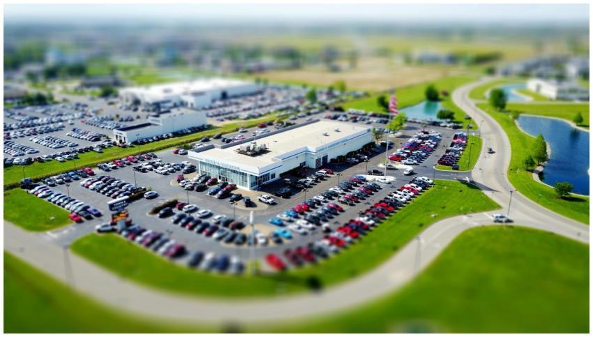 Aerial high-angle view of a bustling car dealershi