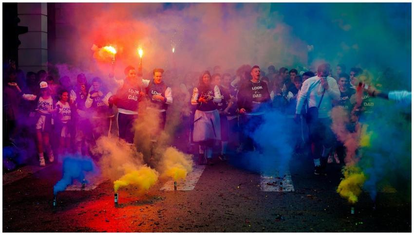 A lively group celebrating at night with color smo