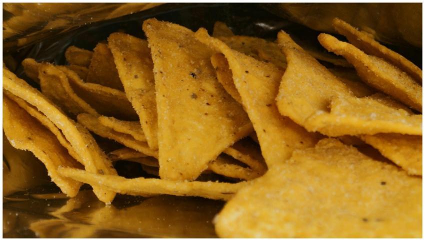 A detailed view of crispy nacho chips inside a met