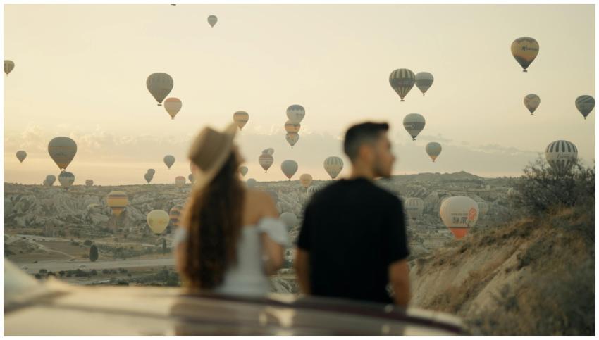 Couple watching hot air balloons at sunrise in Cap