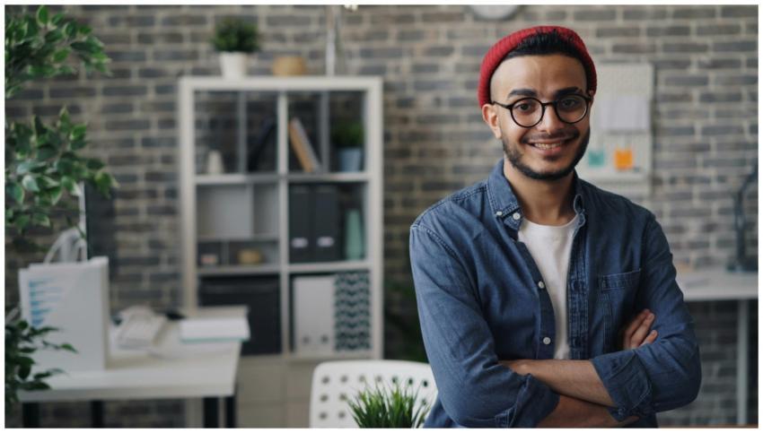 Confident young man in glasses smiling at camera i