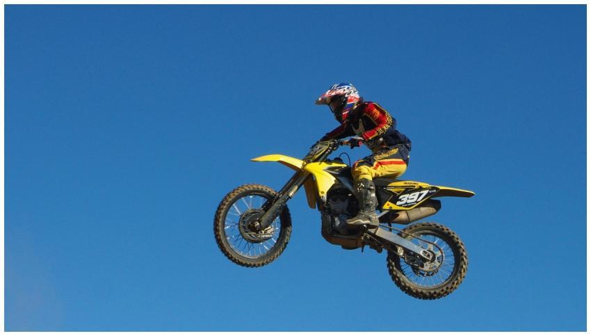 A motocross rider performs a daring jump on a yell
