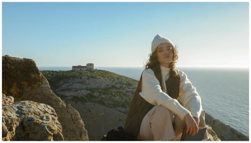 A woman enjoys a tranquil sunset overlooking the s
