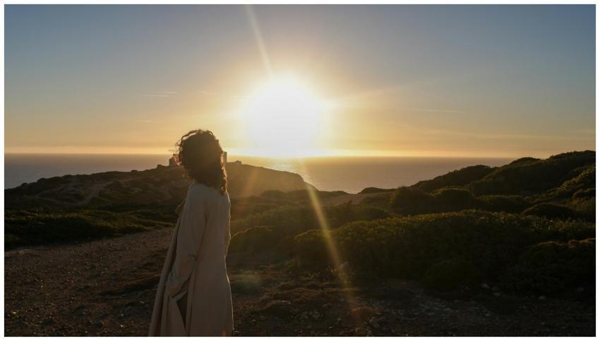 Silhouette of a person in a trench coat watching a
