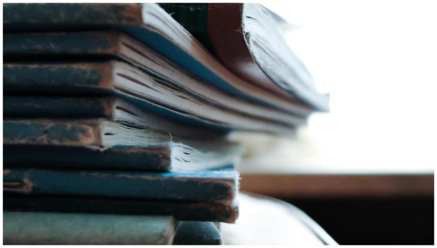 Artistic close-up of a stack of worn out notebooks
