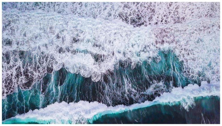 Dynamic aerial shot capturing turquoise ocean wave