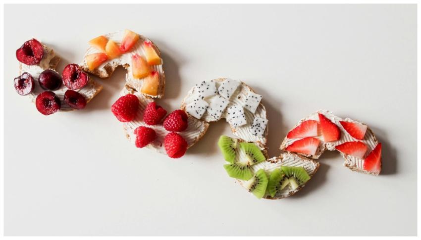 Sliced bagels topped with various fresh fruits cre