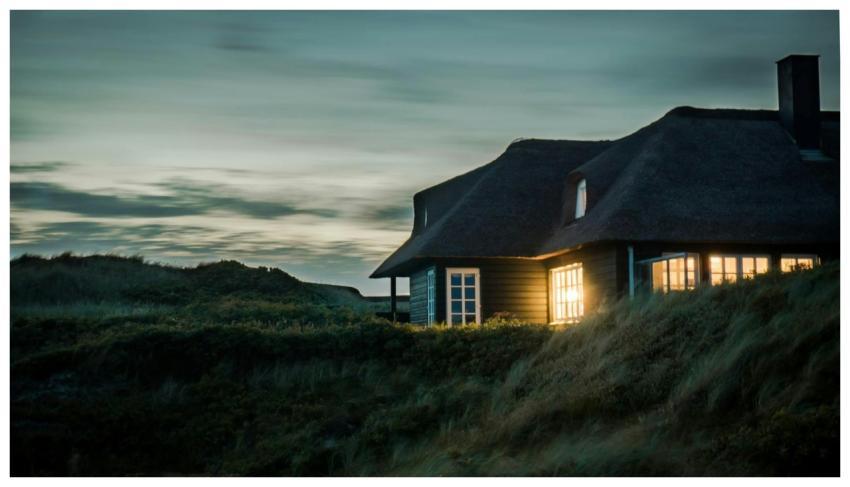 A scenic view of a cozy bungalow illuminated at du