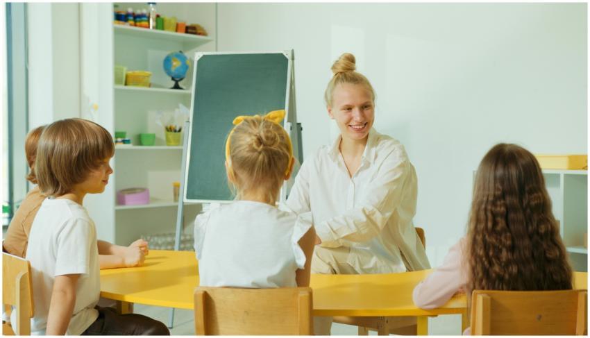 Teacher engaging with preschool children in a colo