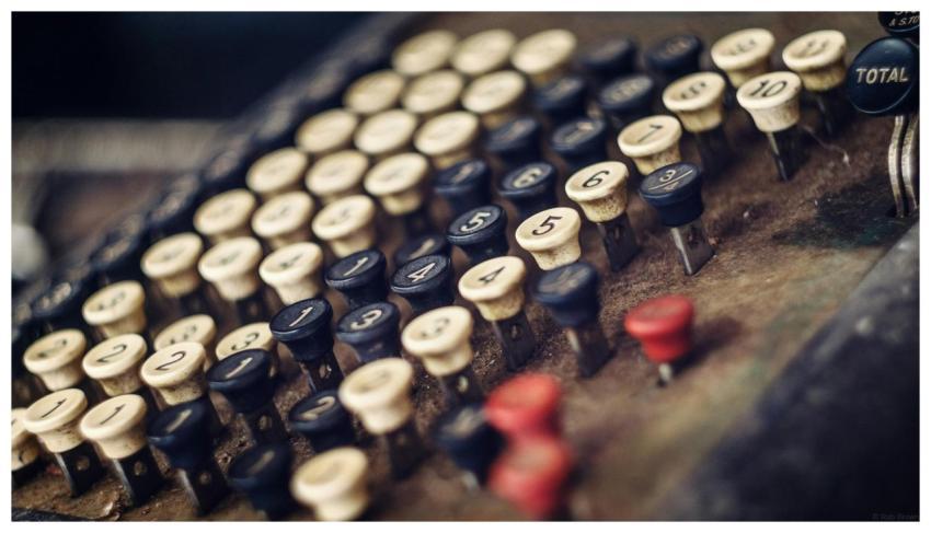 Close-up photo of an antique cash register with nu