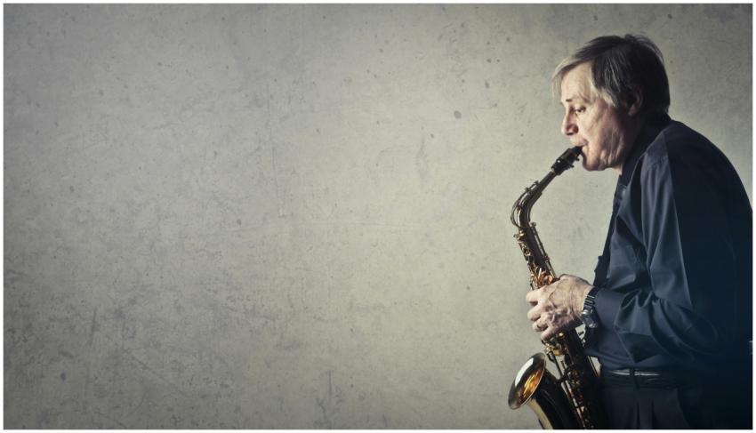 Elderly man passionately plays saxophone against a