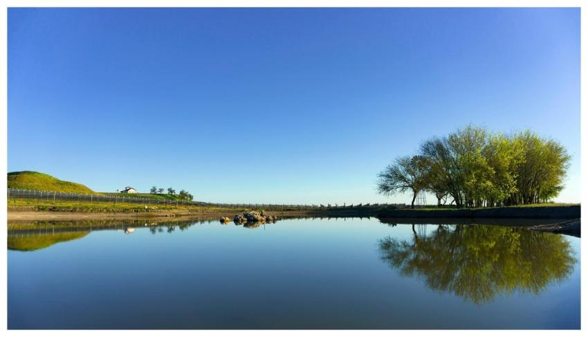 Peaceful rural landscape featuring a serene lake r