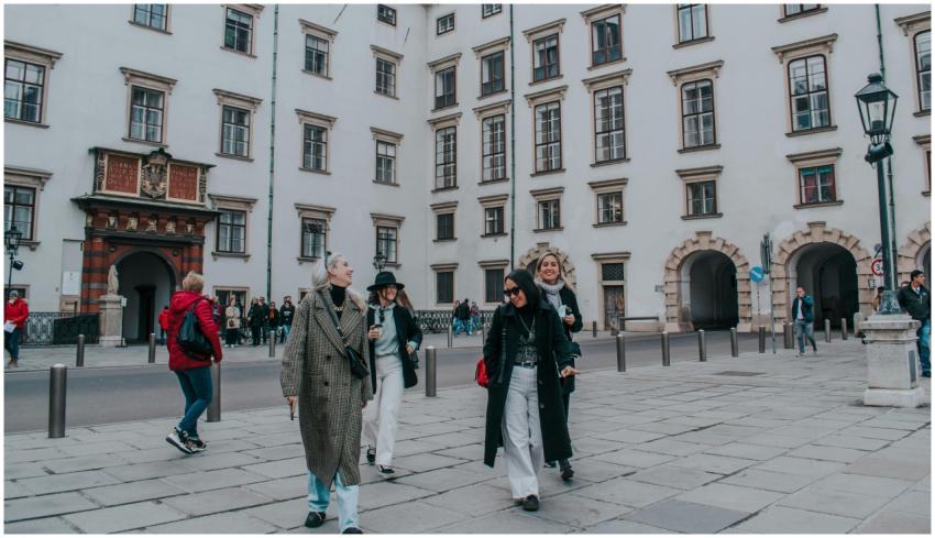 Four women walking and smiling in front of a histo